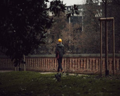 A person taking a calm walk in a city park in Italy